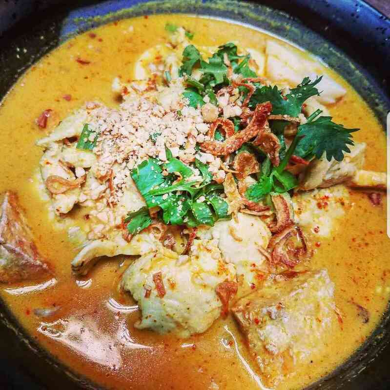 Thai cuisine plated with traditional accompaniments and bright garnishes.